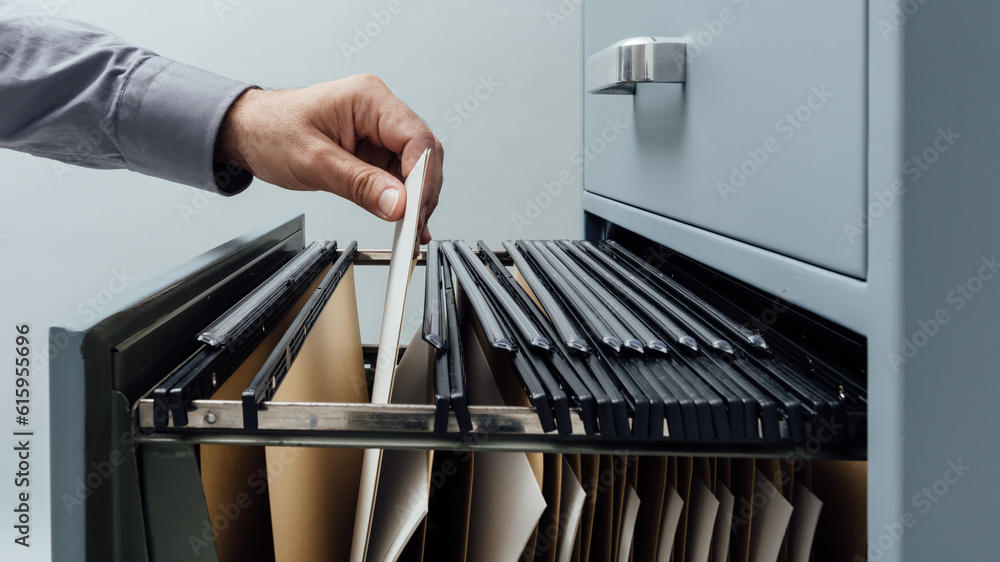 Poster office clerk searching for files into a filing cabinet drawer close up, business administration and 