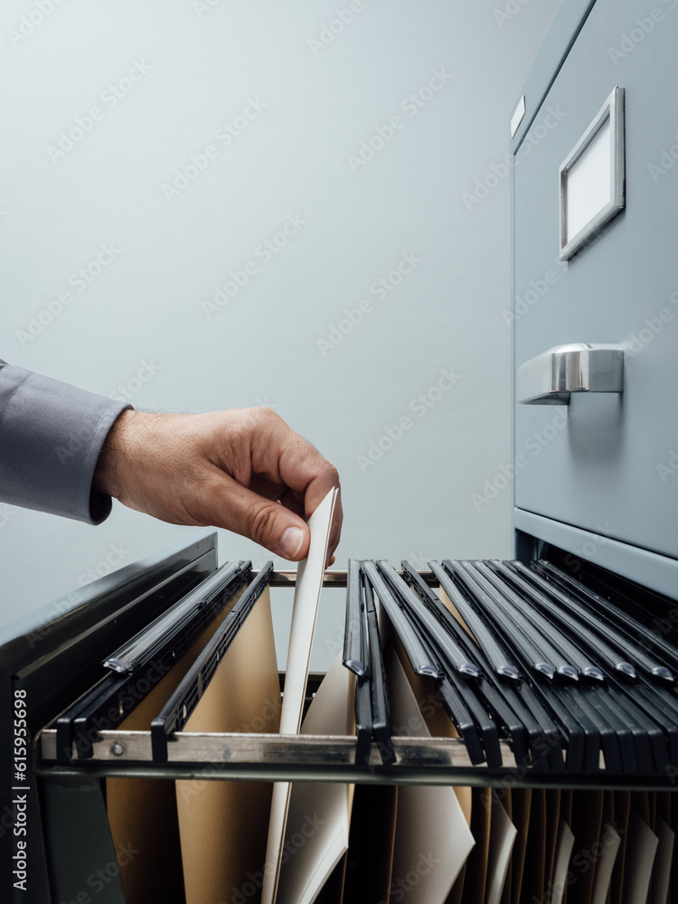 Poster office clerk searching for files into a filing cabinet drawer close up, business administration and 