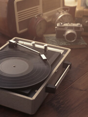 Vintage retro revival objects and appliances assortment on a table, turntable record player on the foreground