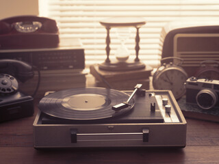 Vintage retro revival objects and appliances assortment on a table, turntable record player on the...