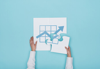 Woman completing a puzzle with a financial graph icon, she is putting the missing piece, finance and business solutions concept