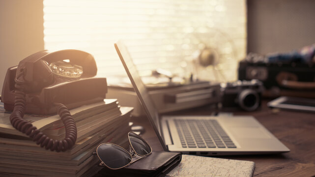 Vintage desktop with laptop, open suitcase and retro objects