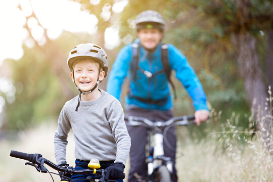 family of two, young father and cheerful son, enjoying bike riding, active family concept
