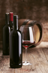 Wine bottles with barrel on wooden background