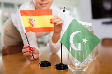 Little flag of Pakistan on table with bottles of water and flag of Spain put next to it by positive...