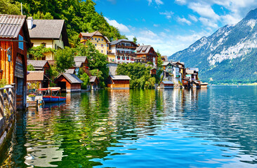 Fototapeta na wymiar Hallstatt, Austria. View to Hallstattersee Lake and Alps mountains. Ancient houses at lake banks. Summer day. Blue sky with clouds.