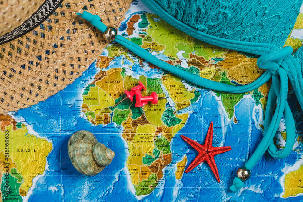 Poster travel destination points on world map indicated with colorful thumbtacks and shallow depth of field