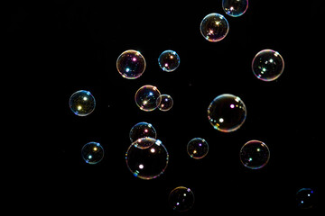Beautiful multicolored soap bubbles on black background for texture and background