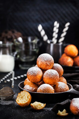 Fresh delicious homemade cottage cheese ball donuts with powdered sugar on dark background