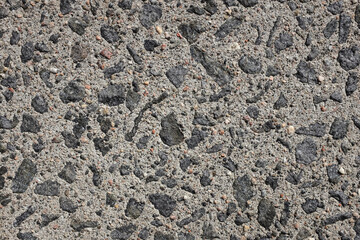 Exposed aggregate concrete paving, with small stones and grit as abstract background texture
