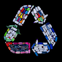 Recycling symbol made from colorful plastic bottles trash - ecology concept, isolated on black