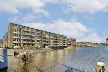 an apartment complex on the water's edge, with boats docked in front and other buildings along the...