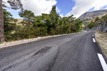 Asphalt road between forests in Provence-Alpes-Cote d Azur region in southeastern France.