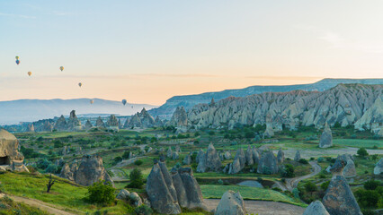 Cappadocia Turkey. Hot air balloons flying over fairy chimneys at sunrise in Cappadocia. Travel to Turkey. Touristic landmarks of Turkiye. Selective focus included.