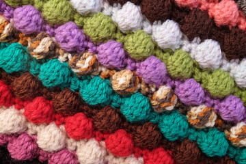 Fototapeta na wymiar Multi-coloured crochet bobble stitches in diagonal stripes, soft yarn abstract background texture