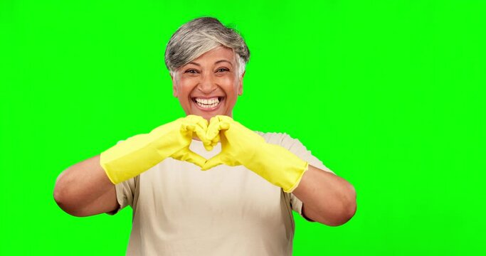 Hands in heart, green screen and woman for cleaning, housework and maid service in studio. Housekeeping, happy and portrait of senior female person with hand gesture for care, love shape and support