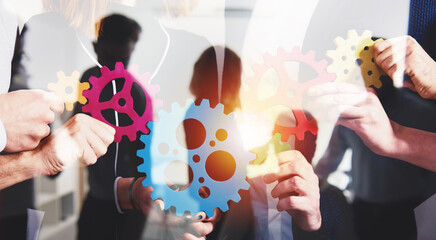 Teamwork of businesspeople work together and combine pieces of gears. Partnership and integration...