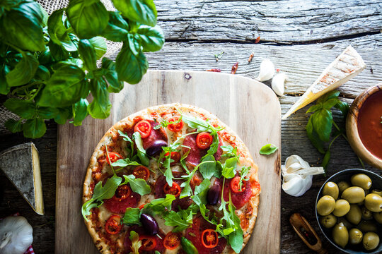 Fresh italian  pizza on wood. Pizza with cheese, salami and tomatoes. Fast food. Rustic pizza