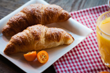 Ingredients for a healthy breakfast - croissant and orange juice, top view.