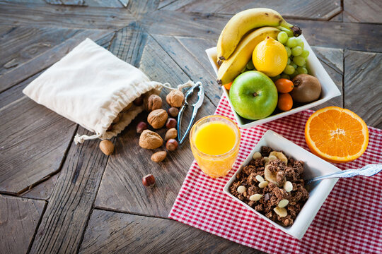 Ingredients for a healthy breakfast - granola honey nuts fruits, top view.