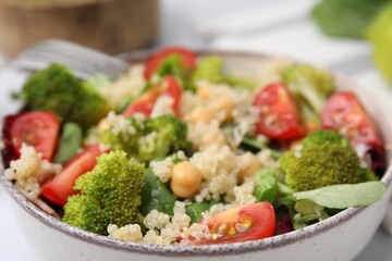 Healthy meal. Tasty salad with quinoa, chickpeas and vegetables in bowl, closeup