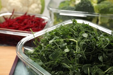 Glass container with microgreens on table, closeup. Food storage
