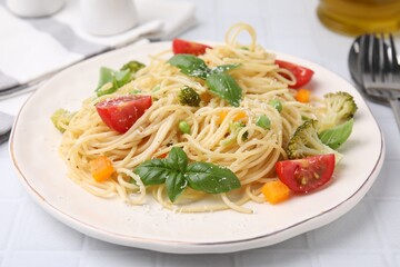 Delicious pasta primavera with tomatoes, basil and broccoli on white table, closeup