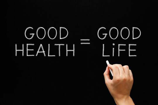 Hand writing Good Health Equals Good Life with white chalk on blackboard.