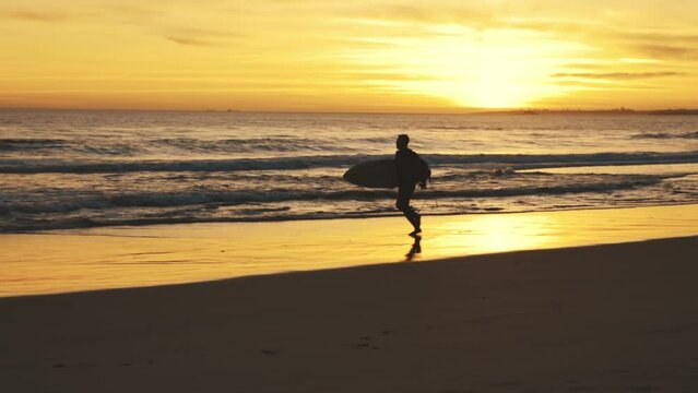 Silhouette of man running on beach at sunset