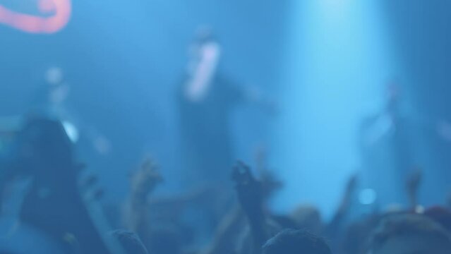 People in crowd shaking hands at a live concert