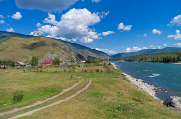 Fototapeta na wymiar Outskirts of the Tungur village on the bank of the Katun river. Altai, Russia. Sunny summer day.