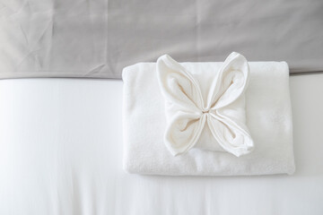 Fototapeta na wymiar Top view of white fresh towel on bed in bedroom in the hotel