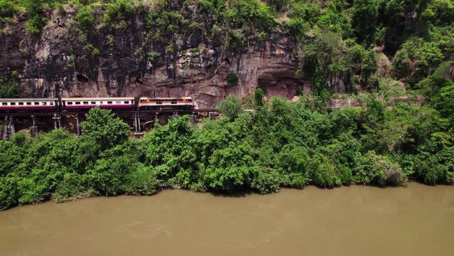 Aerial drone Thailand-Burma Railway Train Maeklong Death Railway bridge over the River Kwai JEATH on mountain pass