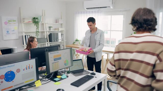Group of businessman and woman eat donut while working in the office.