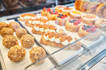 fresh pastries with berries. A variety of fresh pastries in the bakery window. almond croissant is fresh and hot in a cafe next to other types of pastries. The interior of an Italian restaurant.