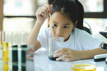 Little child with learning science class in school laboratory