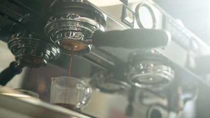 Espresso machine pouring coffee in a glass cup. Close up
