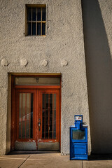 adobe building with blue newspaper box
