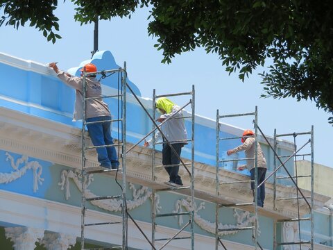 workers on a construction site painting a building