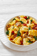hot tortellini with mushrooms, spinach and bacon