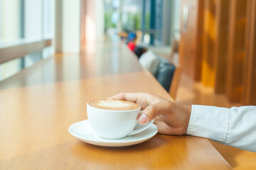Coffee break for relax Hand hold cup of hot coffee in meeting room