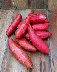 Dozen freash red sweet potatoes on wood texure background