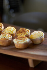 Cupcake, dessert and bakery confectionery closeup, presentation and food with sweet baked goods. Luxury snack, frosting and sprinkles, hospitality and catering industry with cake on wooden table