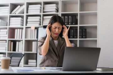 Businesswoman touching head with hand after exhausted and headache from work hard about new project