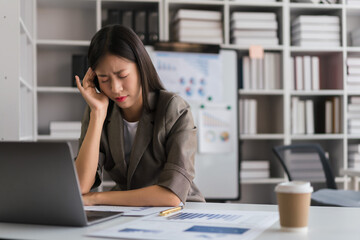 Fototapeta premium Businesswoman touching head with hand after exhausted and headache from work hard about new project