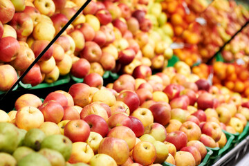 Health, supermarket and closeup of red apples for nutrition, wellness or organic raw diet. Food, shop and zoom of healthy, natural and fresh fruit in baskets at retail farmers market or grocery store