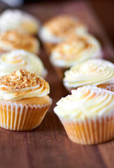 Cupcake, dessert closeup and bakery presentation, food and confectionery with sweet baked goods. Luxury snack, frosting and sprinkles, hospitality and catering industry with cake on wooden table