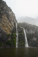 Water falls down waterfalls in the The River Cleddau in Milford Sound, in the South Island of New Zealand