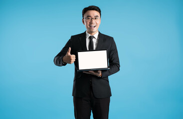 image of asian business man using laptop on blue background.