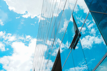 Open window glass in a multi-story building reflecting the enchanting cloudy blue sky - Powered by Adobe